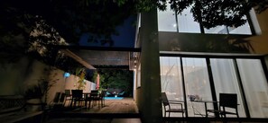 Uma área de estar ao ar livre com piscina, deck de madeira e móveis modernos.