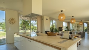 A spacious kitchen with a large island, modern appliances, and a view of the outdoors.