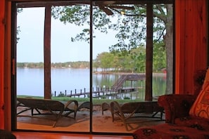Relax in a room with a lake view, featuring a sofa and wicker chairs for unwinding.