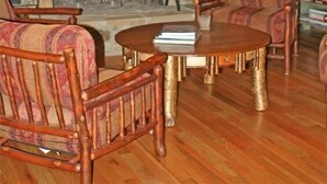 A cozy log cabin interior with a stone fireplace, wooden furniture, and antler chandeliers. - Mountain Style Log Home Main Channel/Patio/Fire Pit/Lake Equipment Rental/Dock (Terrell)