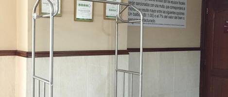 Un chariot dans un couloir, avec des certificats accrochés au mur.