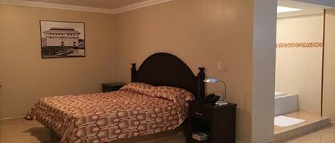 A bedroom with a bed, nightstand, and a picture of a building on the wall.
