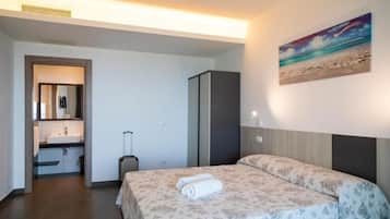 Une chambre d’hôtel avec un lit, une salle de bain et un tableau au mur.