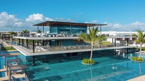 A modern hotel with a rooftop bar, a swimming pool, and lounge areas.