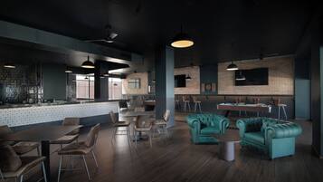 Un restaurante moderno con piso de madera oscura, sofás tapizados en color verde azulado e iluminación colgante.