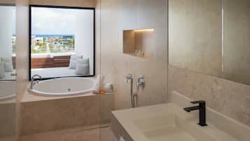A modern bathroom with a large bathtub, a separate shower area, and a vanity with a mirror.