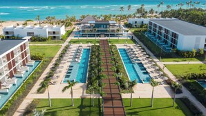 Een resort met een centraal gelegen zwembad, diverse gastenkamers en uitzicht op de oceaan.