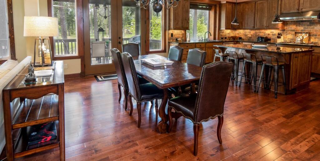 A spacious kitchen with wooden cabinets, a large island, and a dining area with a wooden table and chairs.