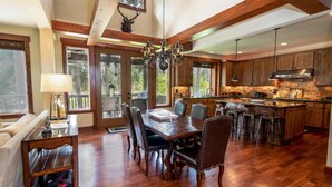 A spacious kitchen with wooden cabinets, a central island, and a dining area with a large table and chairs. - Golf View, Hot Tub, Suncadia Pool Access (Cle Elum)