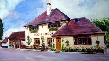 Step into the charming Dog & Crook pub, featuring a classic facade with a pitched roof and welcoming entrance.