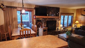 A cozy living room with a fireplace, wooden furniture, and a television.