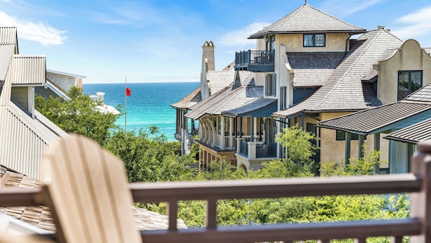 A coastal property with a view of the sea, featuring multiple buildings with balconies and a deck area. - Webb Isle Cottage - Close to Shopping, Dining & the Beach! Free Fitness/Tennis (Panama City Beach)