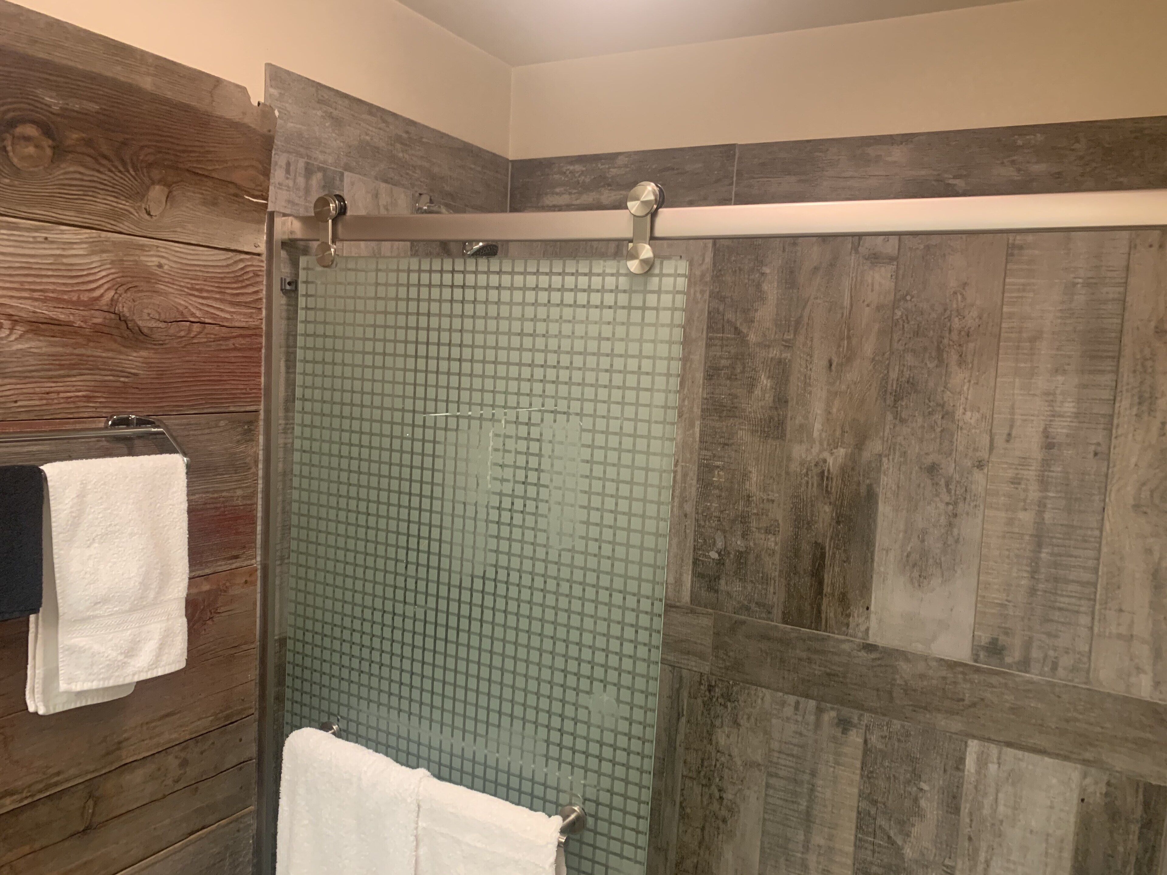 Eine Dusche mit Holzverkleidung und Glastür.