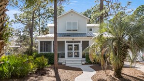 A two-story house with a covered porch, a front entrance with a door, and a number '330' on the door. - Hakuna Matata - 2 Community Pools, Tennis, & Bikes (Santa Rosa Beach)