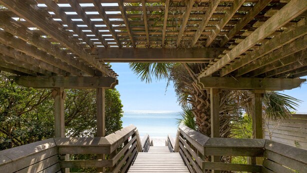 A wooden boardwalk leading to a beach with a wooden pergola overhead. - Hakuna Matata - 2 Community Pools, Tennis, & Bikes (Santa Rosa Beach)