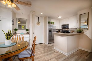 Enjoy cooking in this well-equipped kitchen with a central island, stainless steel appliances, and ample dining space.