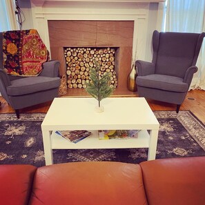Cozy living room with a fireplace, armchairs, and a coffee table.