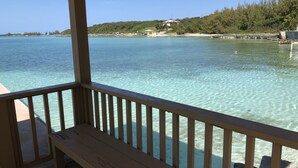 A wooden deck with a railing overlooking clear turquoise water.