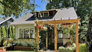 Ein Haus mit einer Holzpergola, auf der die Nummer "7206" steht, und einem Garten mit Pflanzen und Blumen.