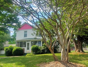 A house with a red roof, surrounded by trees and a well-maintained lawn.