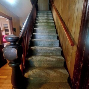 A staircase with wooden handrails and a black balustrade. - The Farm House at Peaks of Otter Winery and Orchards (Bedford)