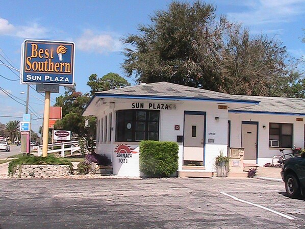 Un pequeño edificio con la leyenda 'Sun Plaza' y un cartel que dice 'Best Southern Sun Plaza'.