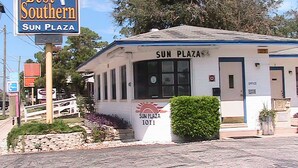A small building labeled 'Sun Plaza' with a sign indicating 'Best Southern' and 'Vacancy'.