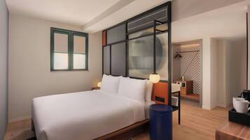 Una habitación de hotel moderna con una cama grande, un escritorio y un rincón de descanso.