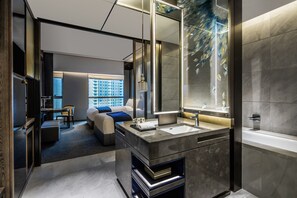 Un baño moderno con un espejo grande, una bañera y un tocador con lavabo.