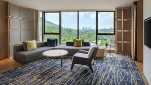 A modern hotel room with a large window offering a view of a city skyline and greenery. - Sheraton Shenzhen Nanshan (Shenzhen)