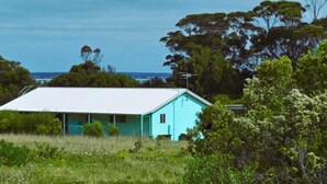 A light blue house with a white roof, surrounded by greenery and trees, with a clear view of the sky and distant landscape. - * * * Aquamarine * * *
Right next to the beach (Baudin Beach)