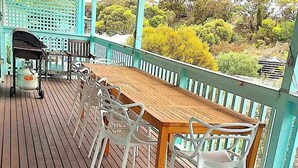 A wooden deck with a table and chairs, a grill, and a view of greenery. - * * * Aquamarine * * *
Right next to the beach (Baudin Beach)