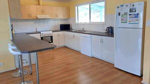 A kitchen with wooden cabinets, a stainless steel refrigerator, a microwave, a sink, and a stove. - * * * Aquamarine * * *
Right next to the beach (Baudin Beach)