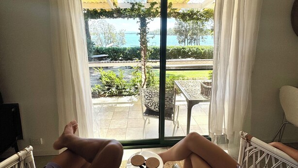 Une chambre avec vue sur une piscine et dotée de mobilier d’extérieur.