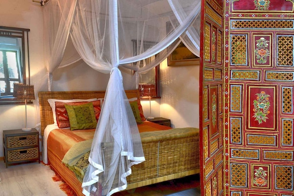 Queen size bed behind privacy screen