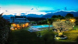 Zona de piscina bien iluminada con vistas a montañas al fondo.