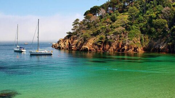 A coastal scene with clear turquoise water, rocky cliffs, and sailboats. - Stunning property isolated, surrounded by nature, 5 min to beaches. Max privacy. (gualta)