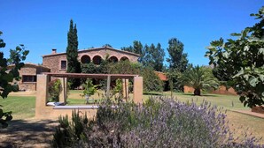 A stone building with arched windows and a garden with lavender plants. - Stunning property isolated, surrounded by nature, 5 min to beaches. Max privacy. (gualta)