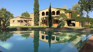 A stone building with arched windows and a pool reflecting its structure. - Stunning property isolated, surrounded by nature, 5 min to beaches. Max privacy. (gualta)