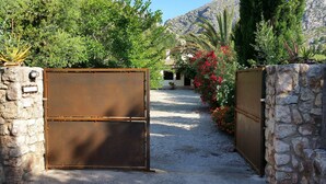 A gated entrance with a gravel path leading to a building. - Country house surrounded by beautiful countryside, with a large pool WIFI FREE (Pollensa)