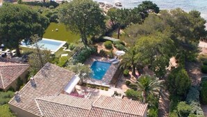 Una proprietà residenziale con piscina, immersa nel verde e affacciata su una spiaggia.