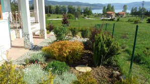 A garden with a variety of plants and a view of a lake and mountains in the background. - Spacious, Well-Equipped Villa With Stunning Views & Multiple Leisure Opportuni (Batak)