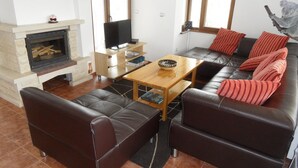 A living room with a fireplace, leather sofas, a coffee table, and a television. - Spacious, Well-Equipped Villa With Stunning Views & Multiple Leisure Opportuni (Batak)