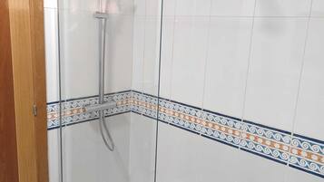 Eine Duschkabine mit Handbrause und Deckenbrause.