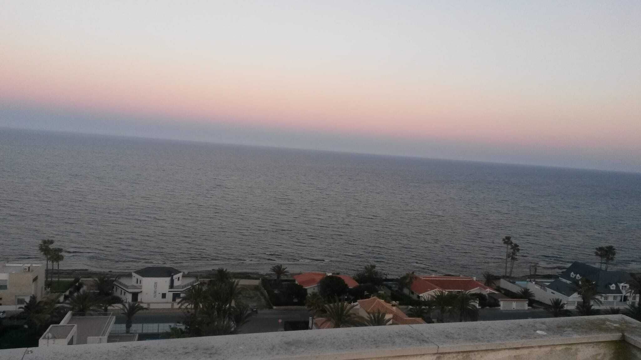 Vista costera con mar tranquilo y cielo despejado.