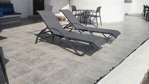 A white building with a dome, a covered patio with lounge chairs, and a tiled floor. - Amazing panoramic sea views!!! (Playa Blanca)