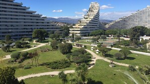 Un moderno complejo hotelero con varias torres, una torre espiral central y jardines bien cuidados.