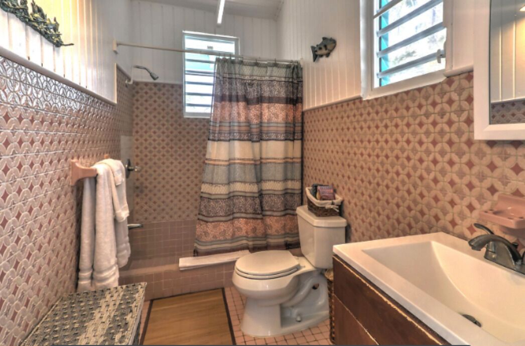 Une salle de bain comprenant des toilettes, un lavabo et un espace douche.