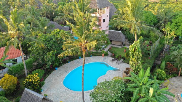 A house surrounded by lush greenery, a swimming pool, and a thatched-roof structure. - Luxurious villa w/pool,10min beach, 280m²,w/ personal & cook, Jacuzzi, A/C,wifi (Kenia)