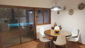 A dining area with a round table, white chairs, and a bowl on the table.